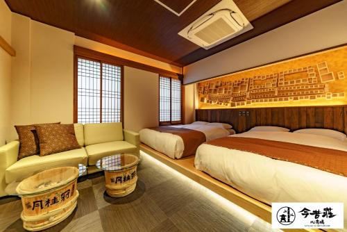 大阪Konjaku-So Shinsaibashi Rooftop SPA的酒店客房配有床、沙发、床和沙发。