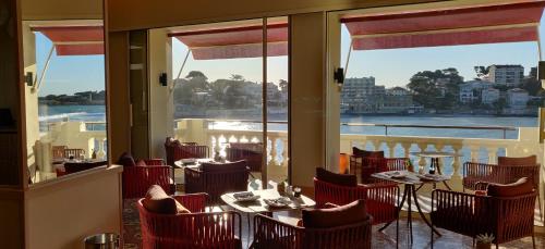 邦多勒Splendid Hôtel & Spa的一间设有桌椅并享有水景的餐厅