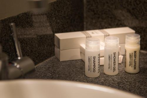 雅加达坦林雅加达自由酒店的一组四瓶,坐在浴室的柜台上
