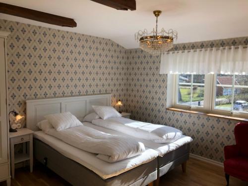英斯约Kastanjelund的一间卧室设有一张床、一个窗户和一个吊灯。
