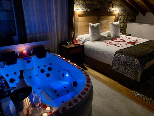 SaroAkla Hotel Suites Valles Pasiegos的带浴缸和床的酒店客房