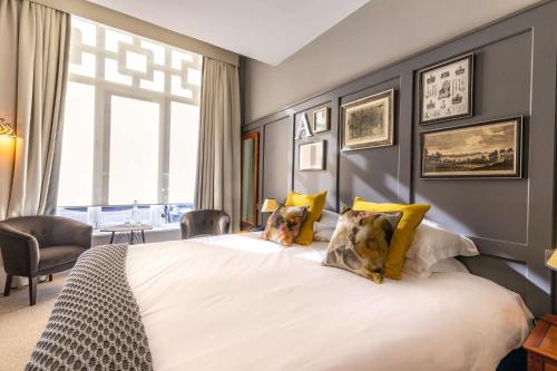 彻特西皇冠酒店的卧室配有一张带黄色枕头的大型白色床。