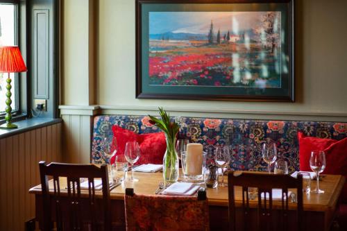 纽伯里卡尔纳翁阿姆斯酒店的用餐室配有带酒杯的桌子