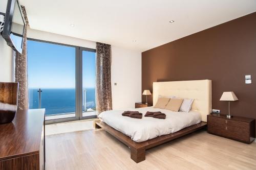 卡列塔Luxo & Conforto的一间卧室设有一张大床和一个大窗户