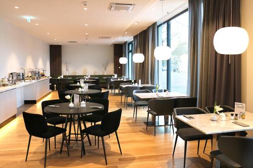 拉芬斯堡GINN City and Lounge Ravensburg的一间带桌椅和柜台的餐厅
