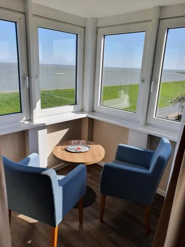 威廉港挪德熙威廉港酒店的客房设有3扇窗户和桌椅。