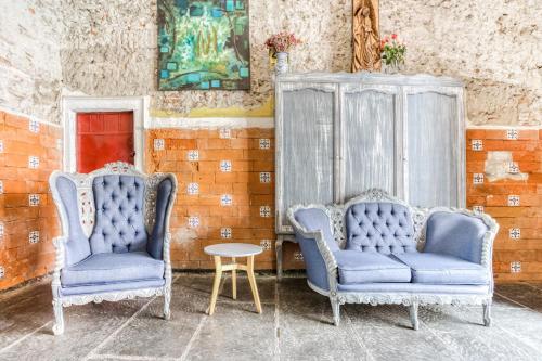 普埃布拉Milagro Hotel的两个蓝色的椅子和一张桌子