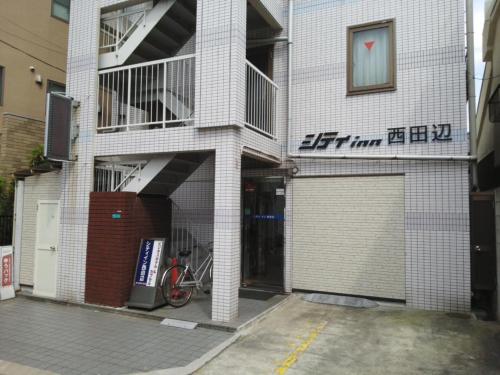 大阪City Inn Nishi Tanabe / Vacation STAY 78538的前面有一辆自行车停放的建筑