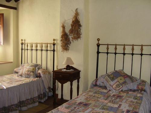 帕劳塔Casa El Menúo的一间卧室配有两张床和一张带台灯的桌子