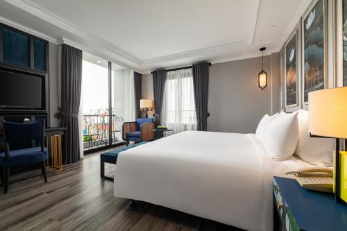 河内Solaria Hanoi Hotel的酒店客房设有一张白色大床和一张书桌