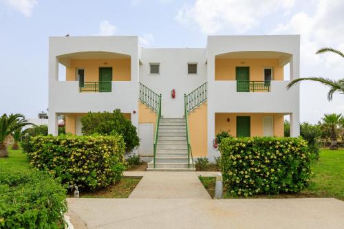 卡尔扎迈纳君主海滩酒店的白色的房子,设有绿色的门和楼梯