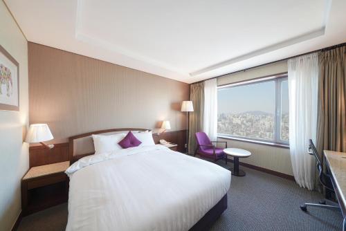 首尔江南贝斯特韦斯特尊贵酒店的酒店客房设有一张床和一个大窗户