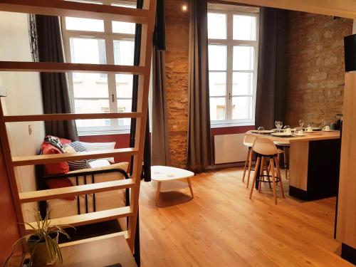 里昂Cosy appartement, dans les pentes de la Croix Rousse的客房设有高架床和桌椅