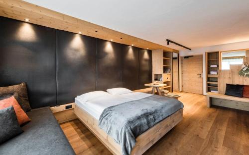 马兰扎Family Home Alpenhof的一间卧室设有一张大床和黑色的墙壁