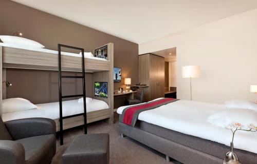 鹿特丹Fletcher Hotel-Restaurant Wings-Rotterdam的酒店客房 - 带两张双层床和椅子