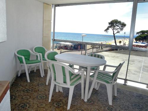维拉福林艾迪埃斯基罗尔维拉公寓的一张桌子和椅子,享有海滩美景
