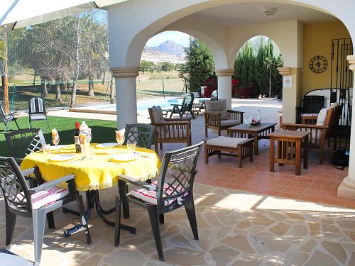 穆特克萨梅尔Holiday Home Bonalba Golf- Urb- Los Naranjos by Interhome的户外庭院设有桌椅和拱门。