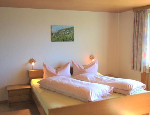 苏尔茨贝格豪斯阿德勒霍斯特酒店的一间卧室配有两张带白色床单和枕头的床。