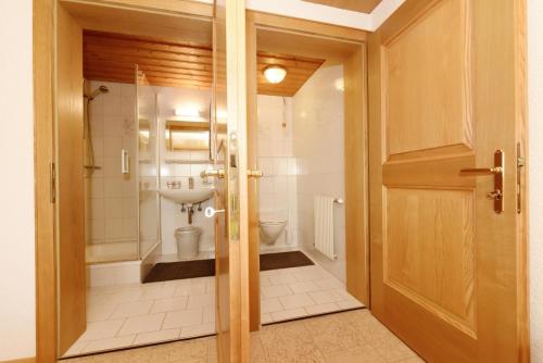 苏尔茨贝格豪斯阿德勒霍斯特酒店的一间带卫生间和玻璃门的浴室