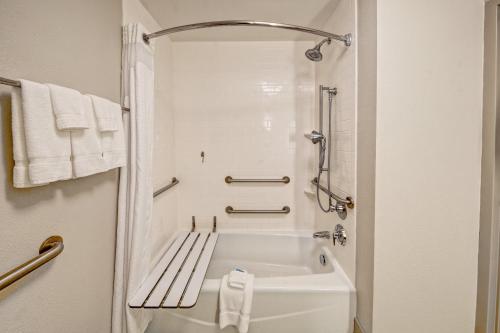 杰克逊杰克逊东北部智选选假日酒店&套房的浴室设有白色浴缸,配有毛巾