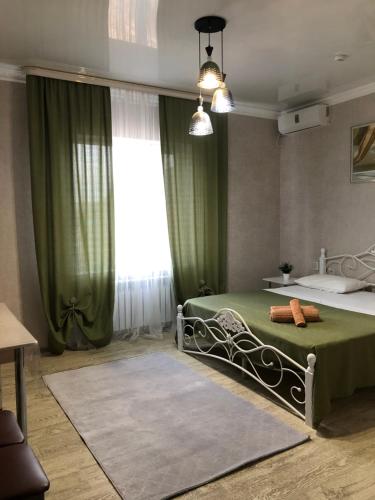 阿克托比Hotel Barhat Аktobe的一间卧室设有一张绿色的床和一个窗户。