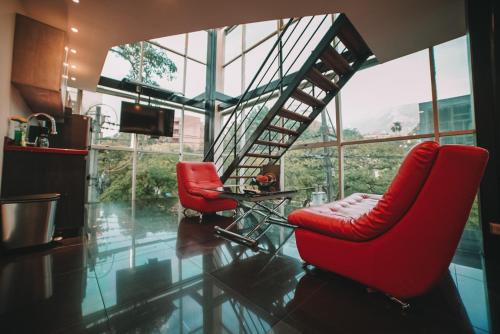 麦德林Provenza Lofts的客厅设有2把红色椅子和楼梯