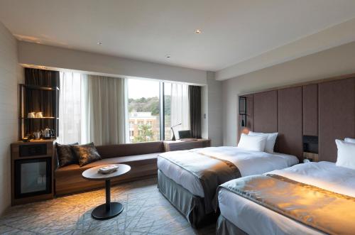 金泽First Hotel Kanazawa的酒店客房,设有两张床和一张沙发