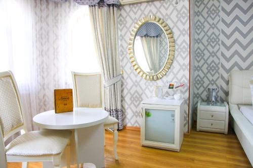 奇姆肯特阿尔特尔酒店的客房设有床、桌子和镜子