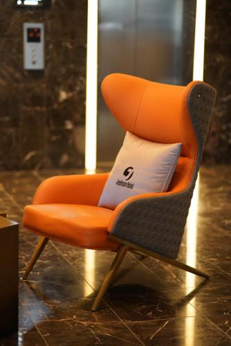 布里斯班杰甫逊公寓及酒店的客房内的橙色椅子和枕头