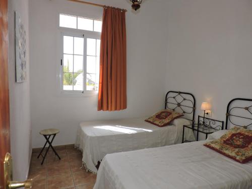 洛斯·亚诺斯·德·阿里丹Casas El Monte, en Los Barros的一间卧室设有两张床和窗户。