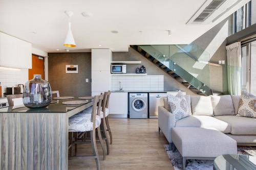 开普敦Always-Power Luxury De Waterkant Loft Retreat的厨房以及带桌椅的起居室。