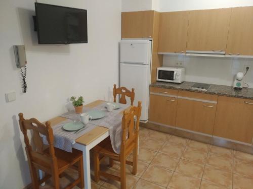 贝萨卢BUHARDILLA PARA DOS EN CAN MINGU的厨房配有桌椅和微波炉。