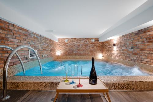 波加茨泽沃Plaża Resort的热水浴池,配有一瓶葡萄酒和酒杯