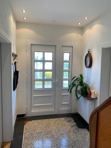 勒讷Die Weinsiedelei的一条带白色门和植物的走廊