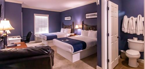 La PlataDepot Inn & Suites的一间蓝色卧室,配有两张床和卫生间