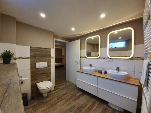 鲁斯特Haus Danny的一间带两个盥洗盆、卫生间和镜子的浴室