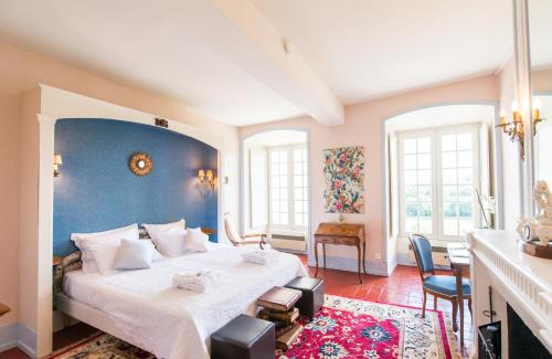 尚托奈珀塞庄园酒店的一间卧室设有一张蓝色墙壁的大床