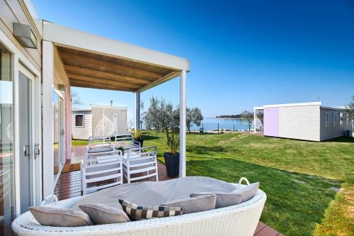 乌马格Mobile Homes Sunset Beach的平台上设有带沙发和椅子的天井