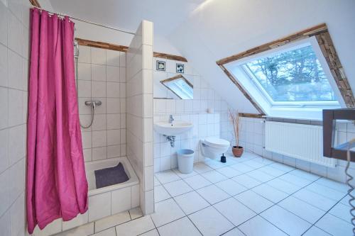 吕本山麓诺伊施塔特Strandhotel Weißer Berg的一间带粉红色淋浴帘和卫生间的浴室