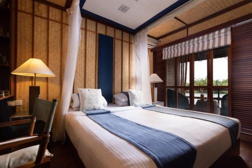 本托塔Yathra Houseboat的一间卧室设有一张大床和一个窗户。