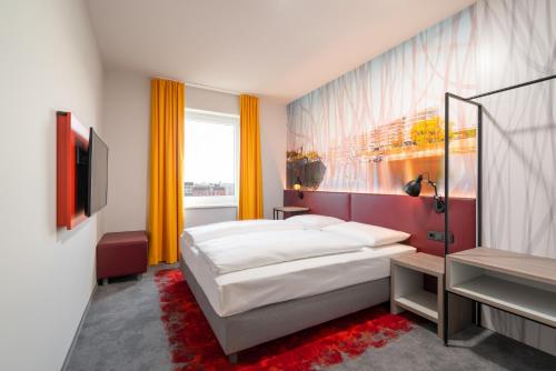 杜伊斯堡Campanile Duisburg City的酒店客房,配有床和电视