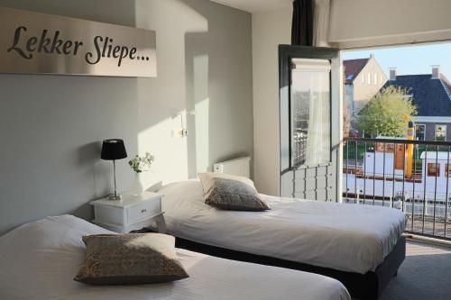 IJlst斯塔德舍伯格旅馆的一间卧室设有两张床,窗户设有阳台
