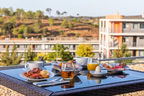 波尔蒂芒Algarve Race Resort - Apartments的桌上的食品托盘,包括饮料和食物