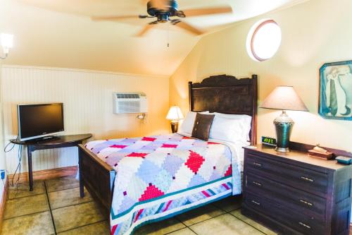 曼蒂奥Roanoke Island Inn的一间卧室配有一张床和一台平面电视