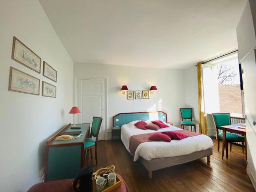 ArsonvalLogis Hostellerie la Chaumière的卧室配有一张床和一张桌子及椅子