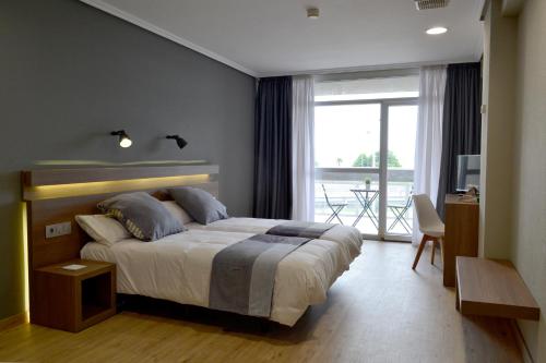 萨达Hotel Alda Sada Marina的一间带大床的卧室和一个阳台