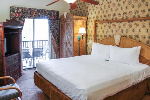 奥兰多公园道国际钻石庆祝场所度假酒店的一间带大床的卧室和一个阳台