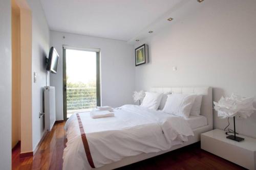 雅典Voula, A modern, minimal and stylish, apartment的白色的卧室设有一张大床和一个窗户