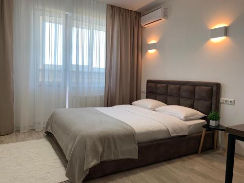 基辅Святобор LUX Apartments的一间卧室设有一张大床和一个窗户。