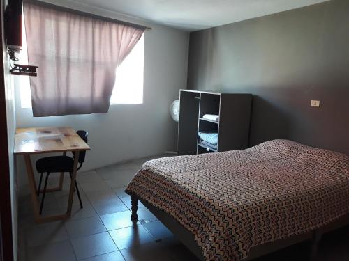 贾拉普Posada Loreto Xalapa的一间卧室配有一张床、一张书桌和一个窗户。
